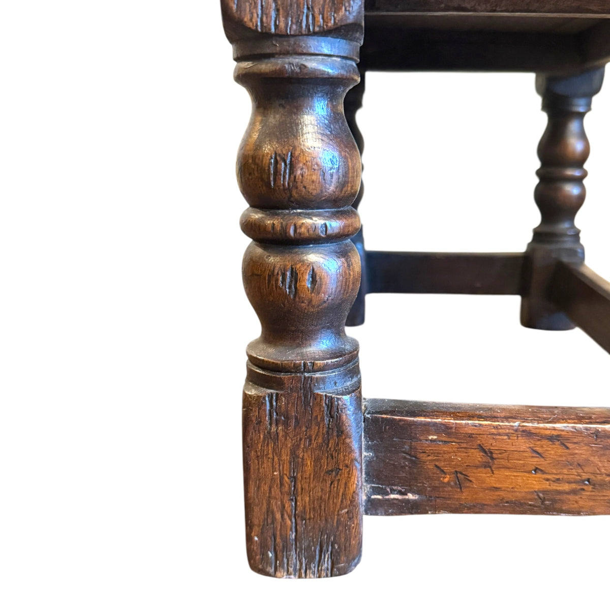 Close-up of baluster-turned oak leg and stretcher showing genuine age wear, knocks and dark oak patina
