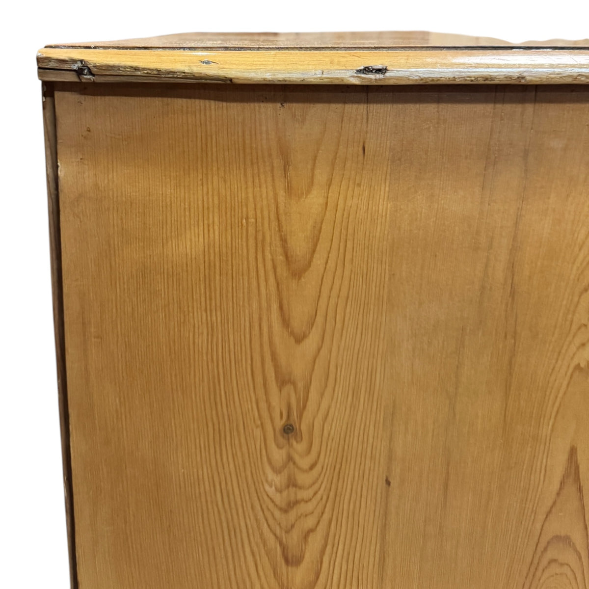 Close-up of aged top edge and natural patina on a Victorian pine chest of drawers.