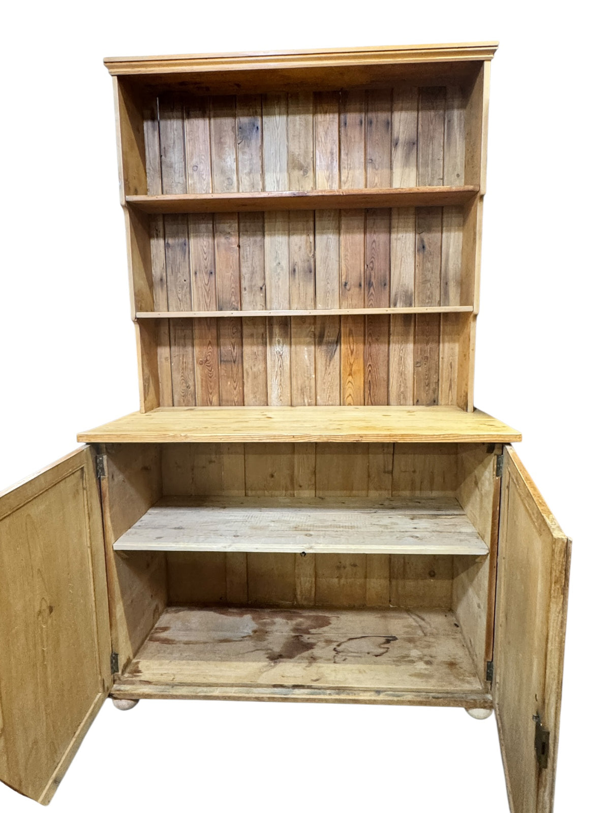 Antique pine kitchen dresser with cupboard doors open, showing internal shelf storage and original boarded interior.