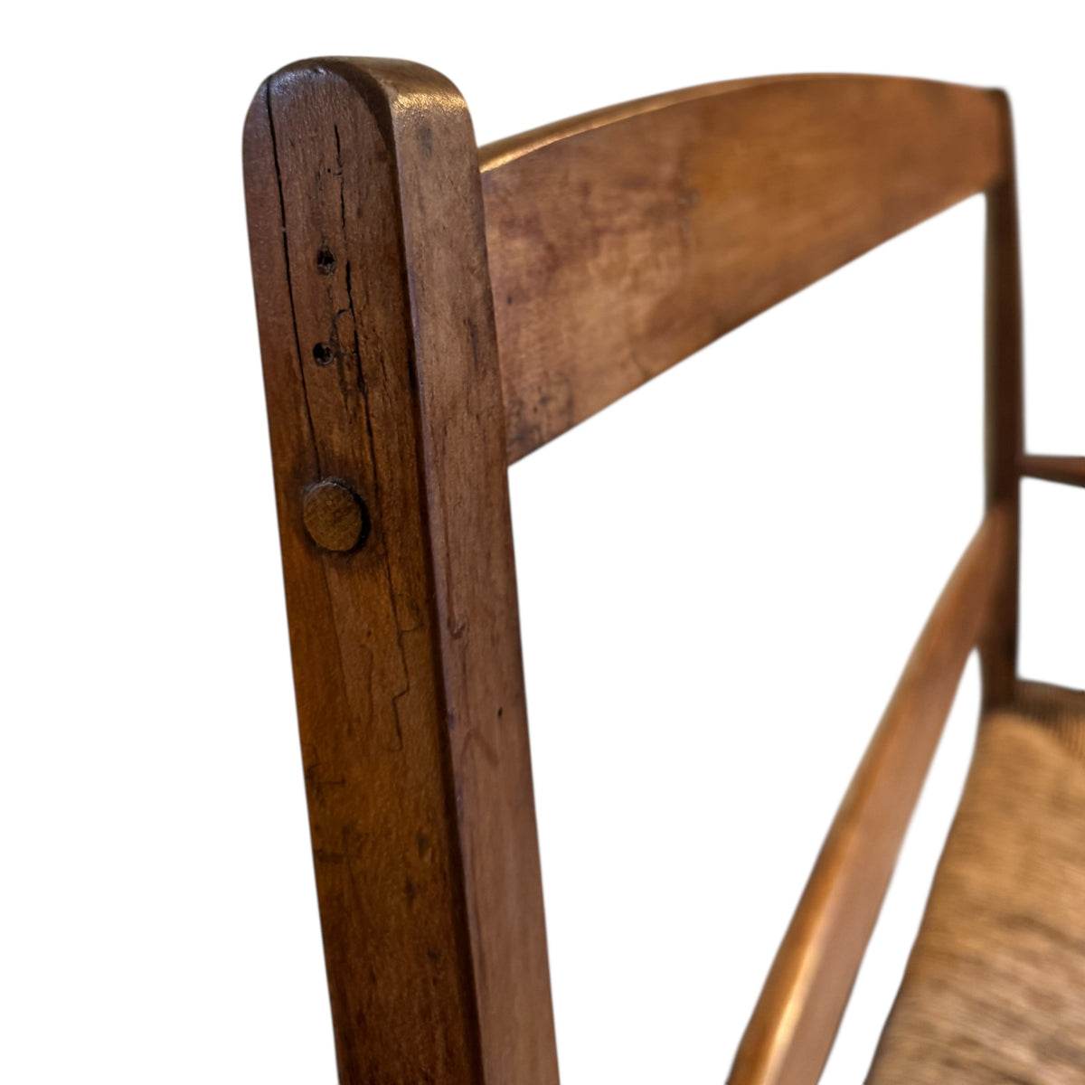 Close-up of walnut back rail and shaped arm joint showing traditional construction and aged patina
