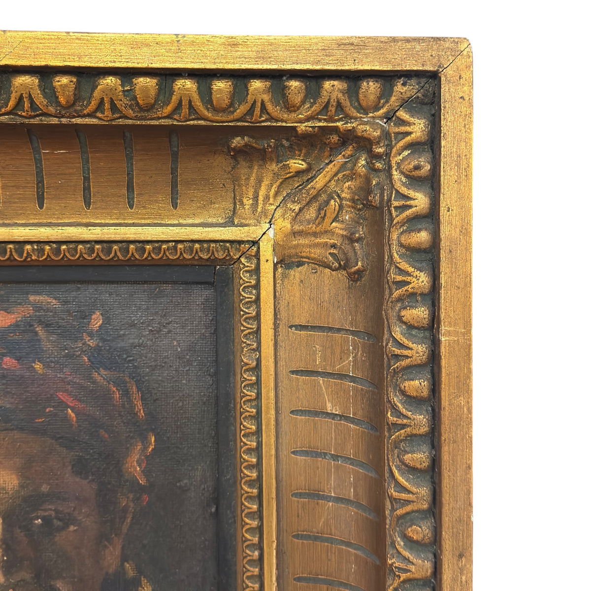 Upper right corner of the gilt frame showing leaf decoration, classical border motifs and visible corner cracks