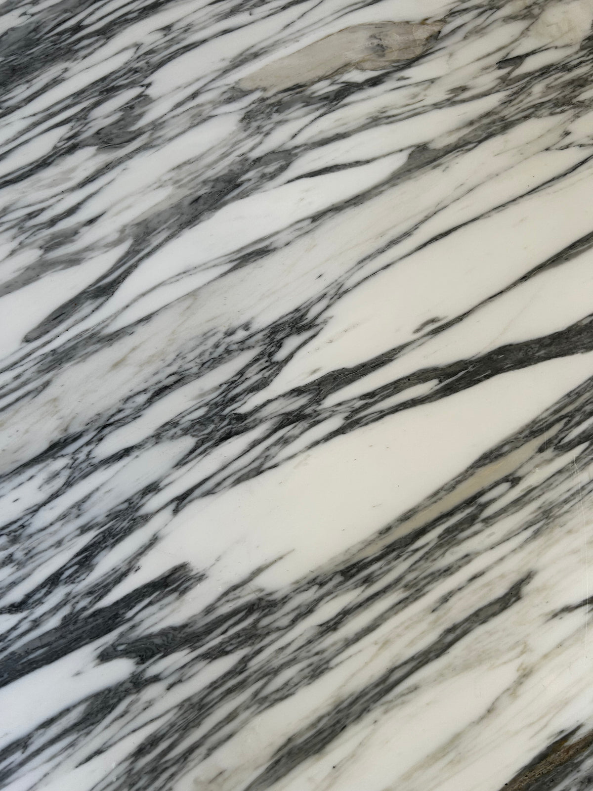Close-up of genuine Calacatta Vagli marble showing dramatic natural grey veining and polished surface detail.