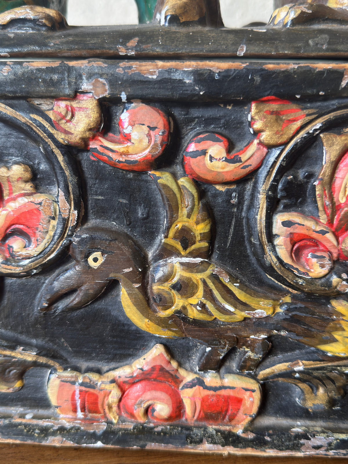 Antique Indian polychrome dowry box showing carved animal motif surrounded by scrolling foliage