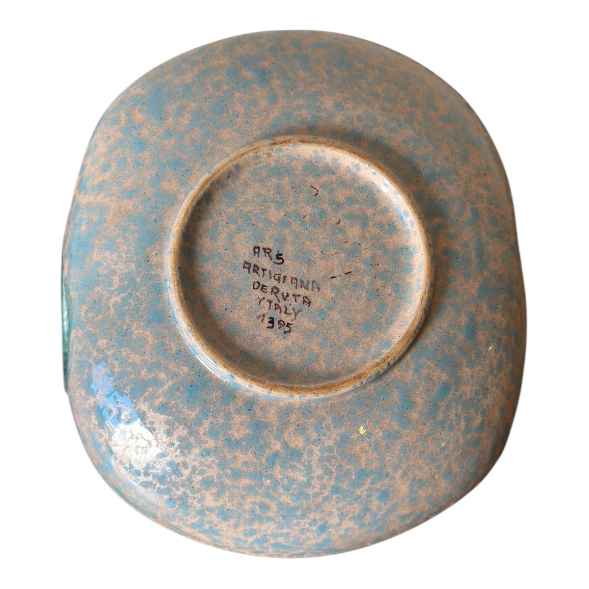 Underside of ARS Artigiana Deruta pottery bowl showing mottled turquoise glaze and hand-painted maker's mark