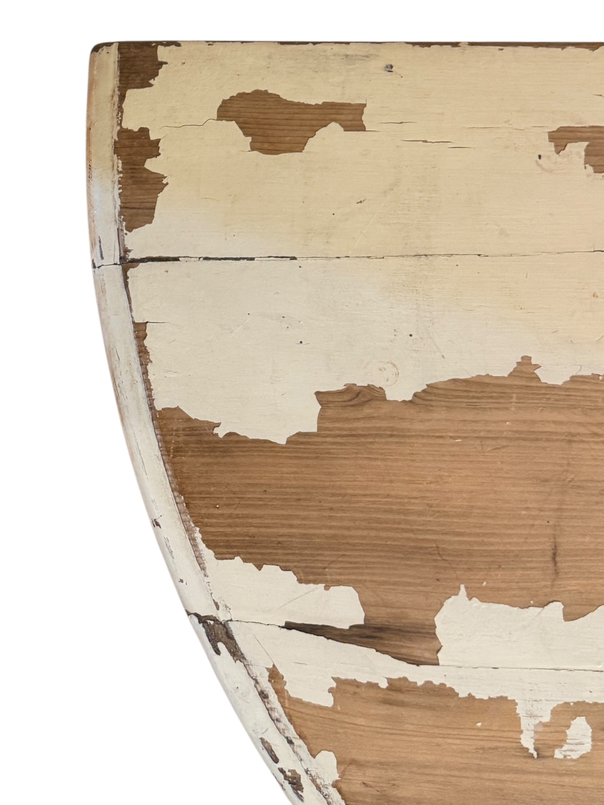 Close-up of distressed cream painted pine table top with extensive natural paint loss revealing warm timber beneath.