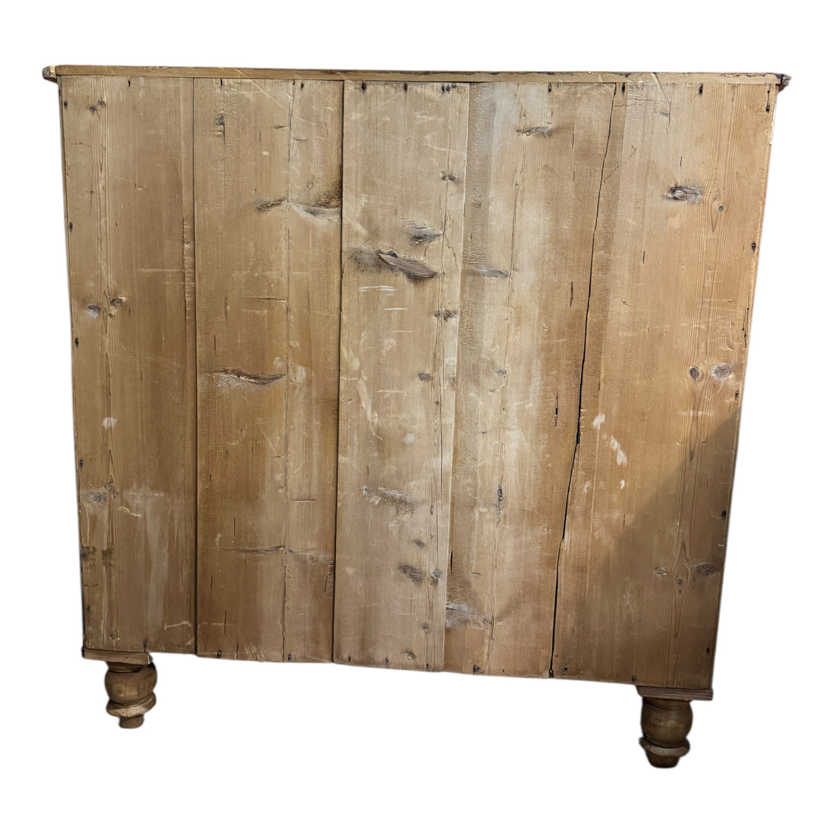 Rear view of 19th century pine chest of drawers showing traditional wide boarded back construction.