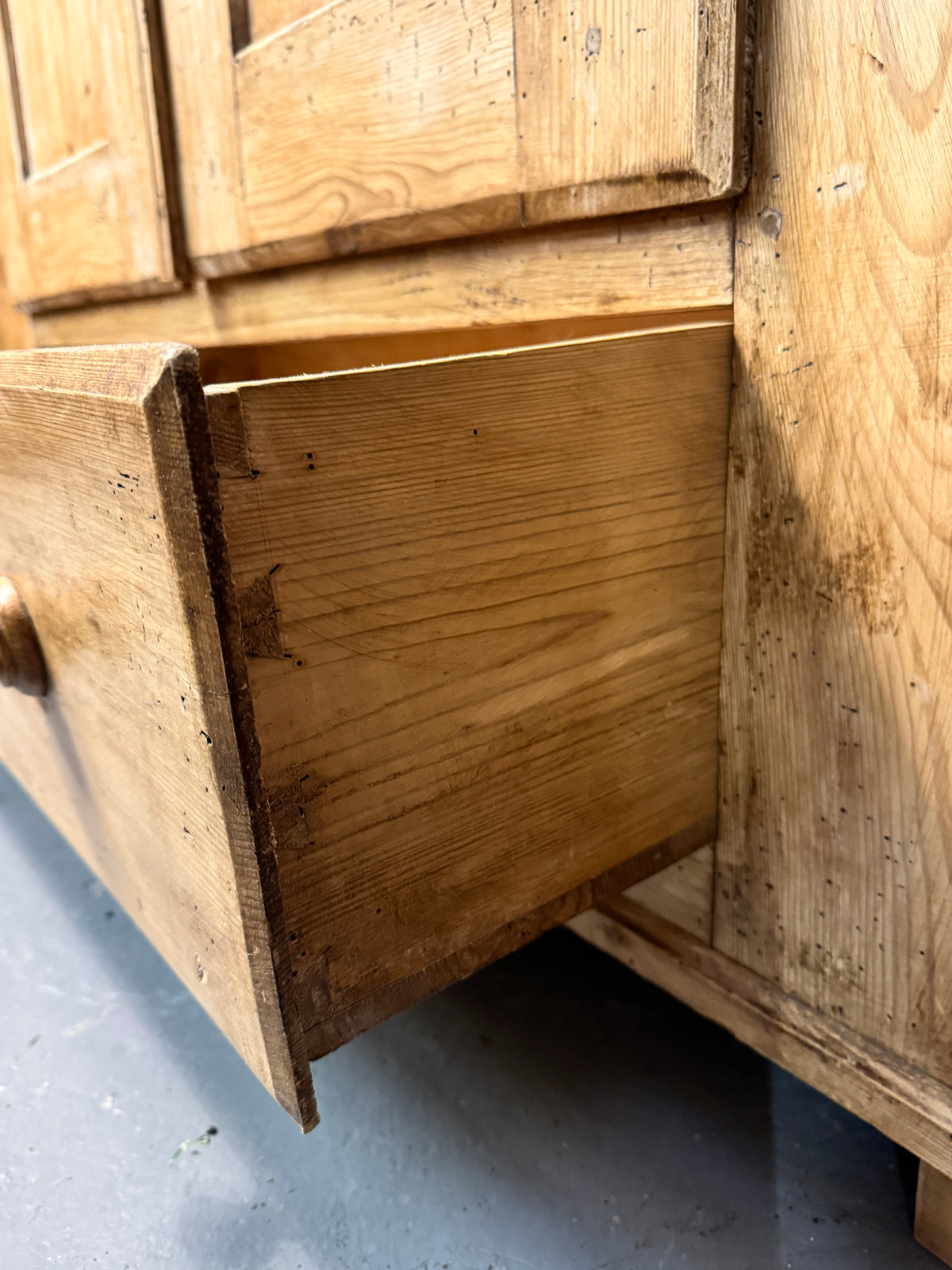 Open lower drawer of antique Victorian pine wardrobe showing traditional solid wood construction