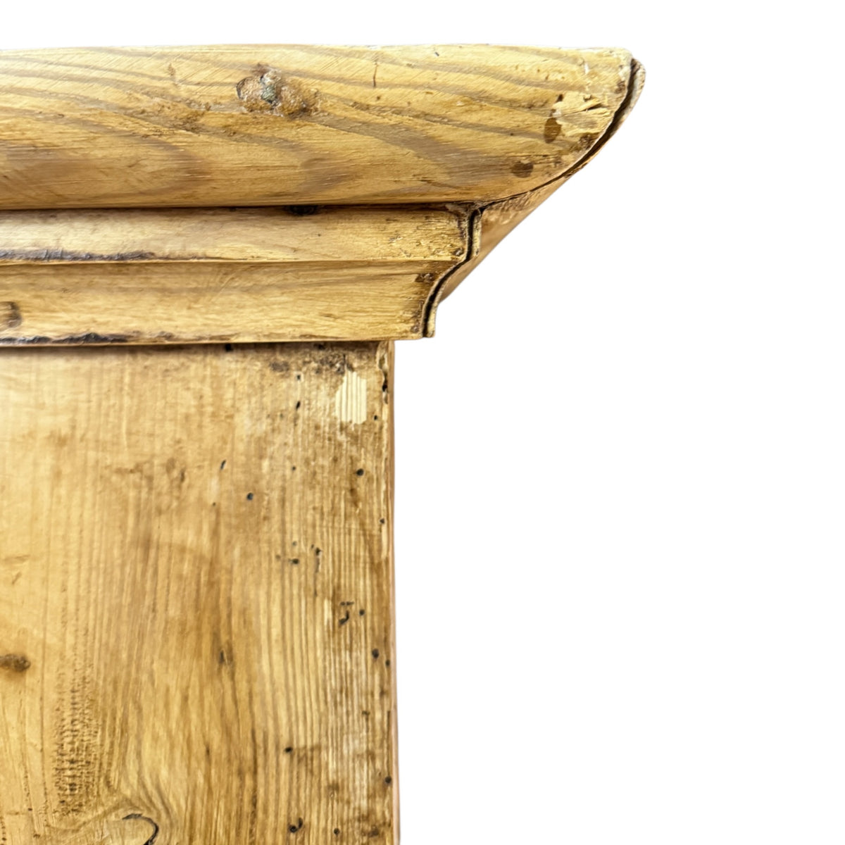 Close-up of the moulded pine cornice on an antique Victorian wardrobe showing natural grain, wear and aged patina