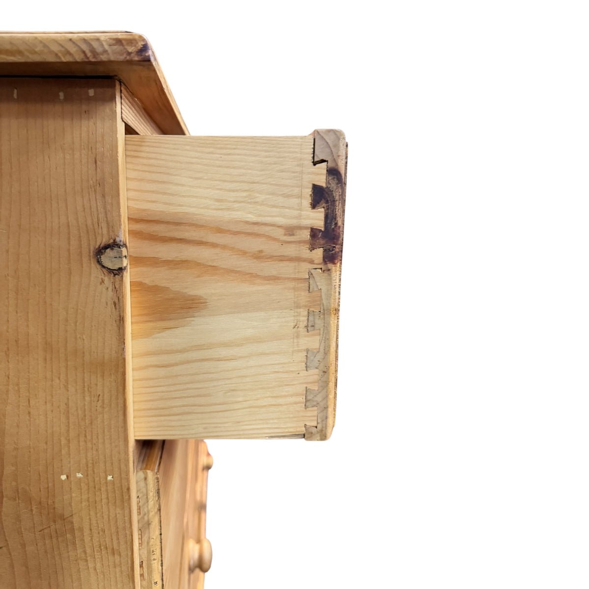 Close-up of dovetailed drawer construction on a vintage pine chest of drawers, showing solid timber sides and traditional joinery.