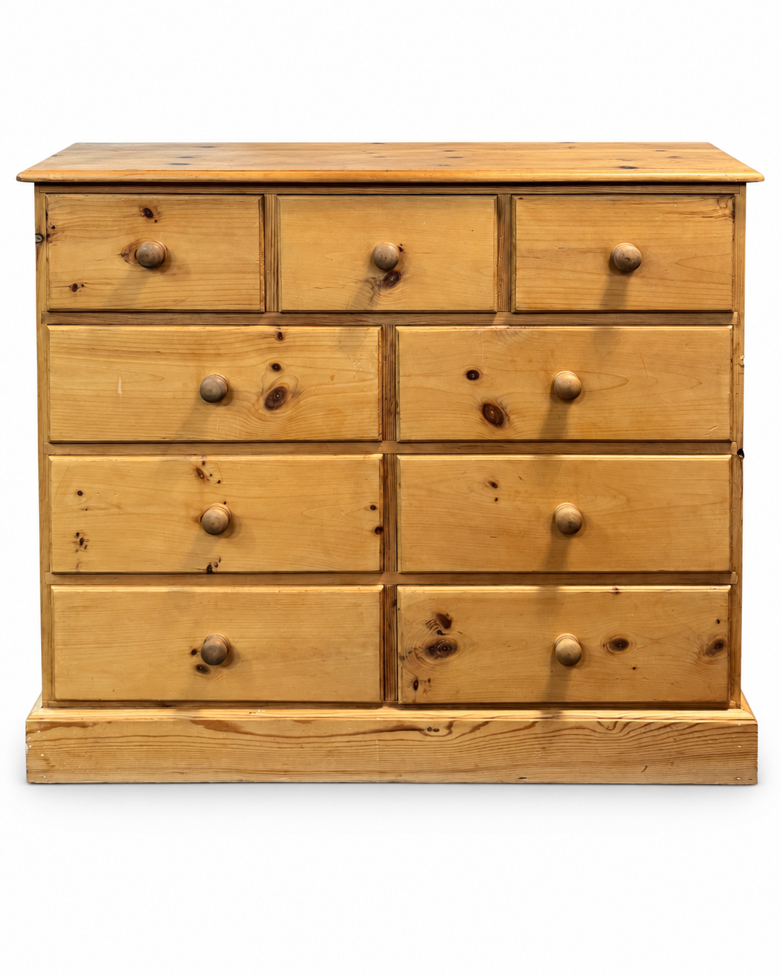 Vintage pine nine drawer chest of drawers with turned wooden knobs photographed front-on against a clean white background.