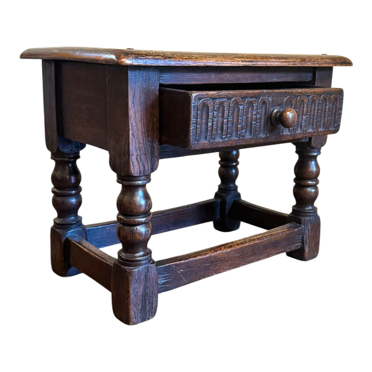 Antique oak joint stool side table shown with single drawer open, carved drawer front and turned oak legs