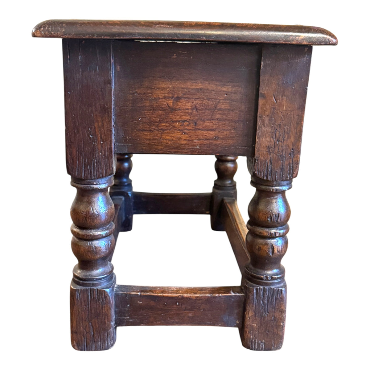 Side view of antique solid oak joint stool side table showing substantial oak construction, turned legs and stretcher base
