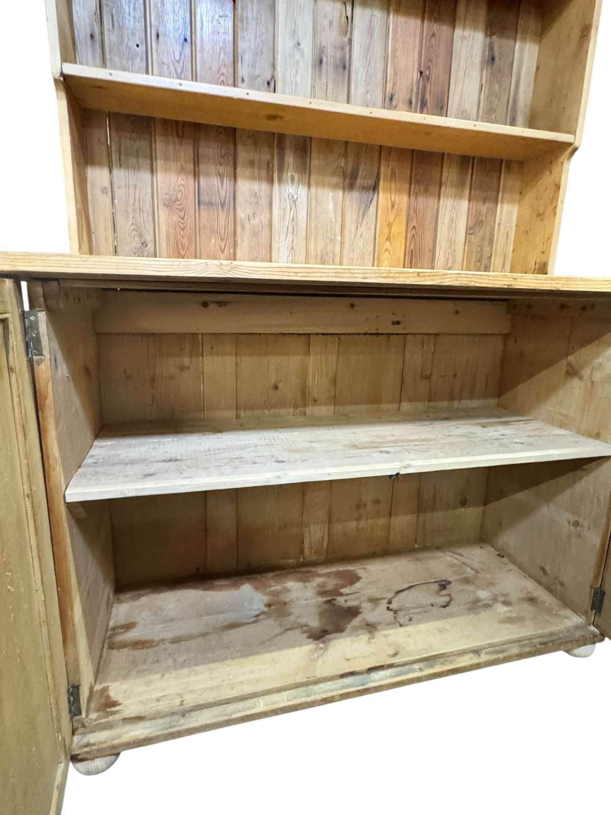 Antique pine kitchen dresser with cupboard doors open, showing internal shelf storage and original boarded interior.