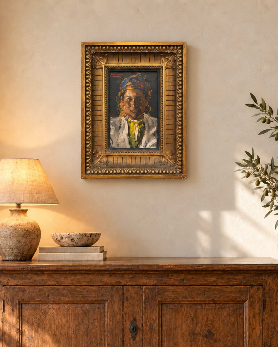 Hugo Backmansson Marrakech portrait in a decorative gilt frame above an antique oak cabinet, with warm lamplight and subtle olive greenery.