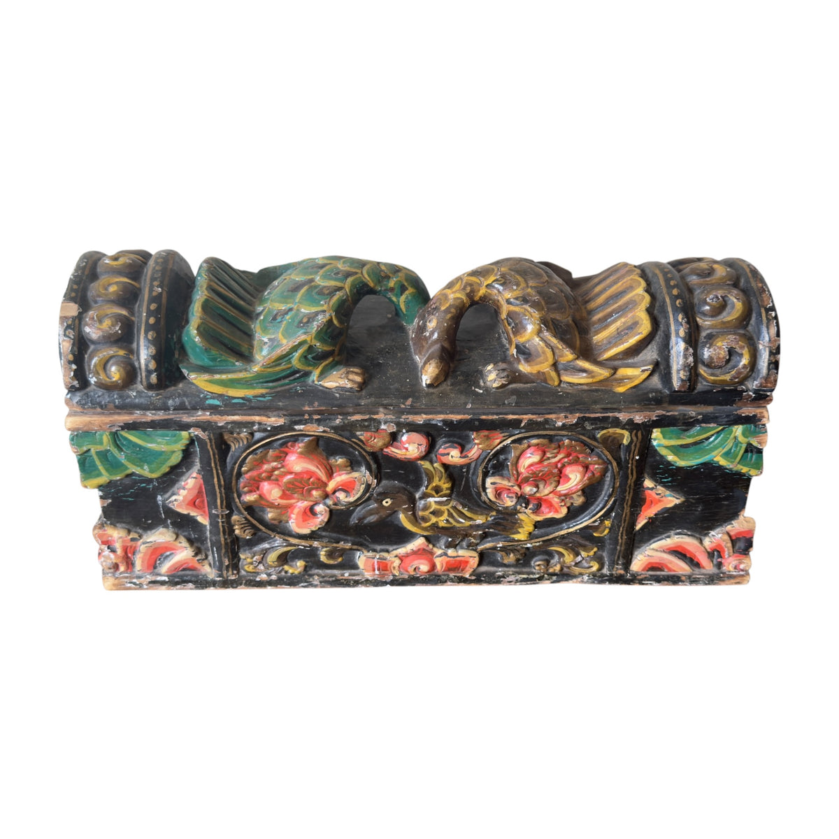 Antique Indian carved wooden dowry box with worn red green and black polychrome, angled front view