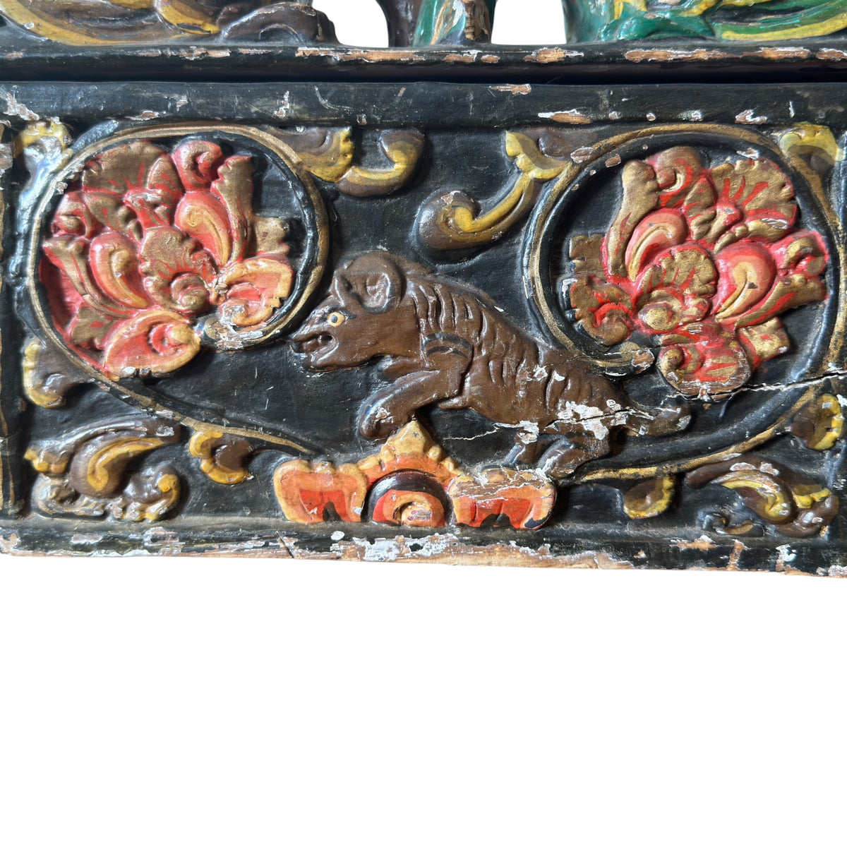 Close-up of antique Indian carved dowry box showing aged polychrome surface, chips and exposed hardwood