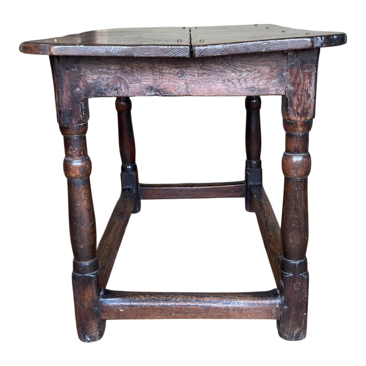 End view of the late 17th century English oak tavern table showing the turned legs, low stretchers and substantial two-board top.