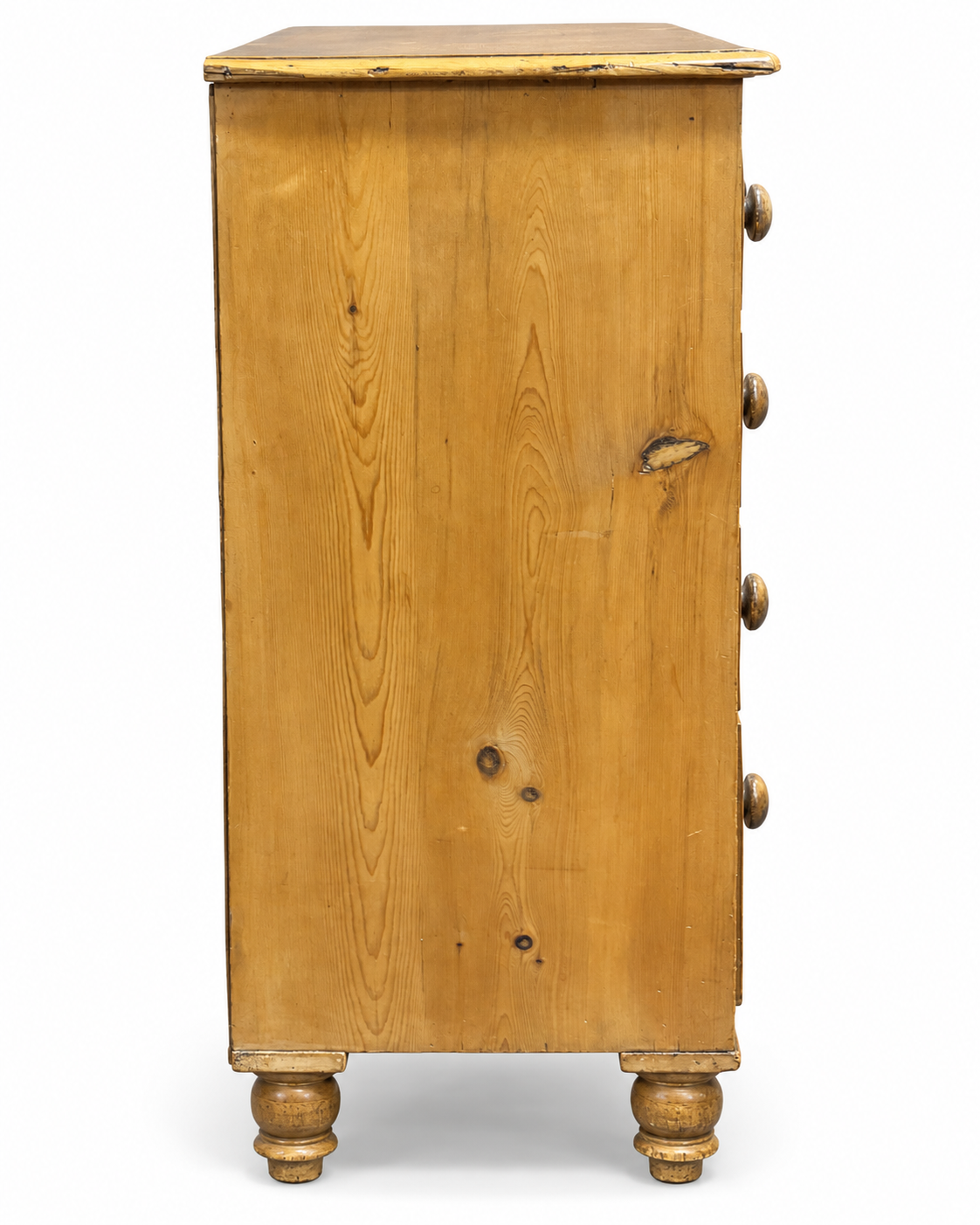 Side view of Victorian pine chest of drawers showing solid pine construction, visible grain and turned feet.