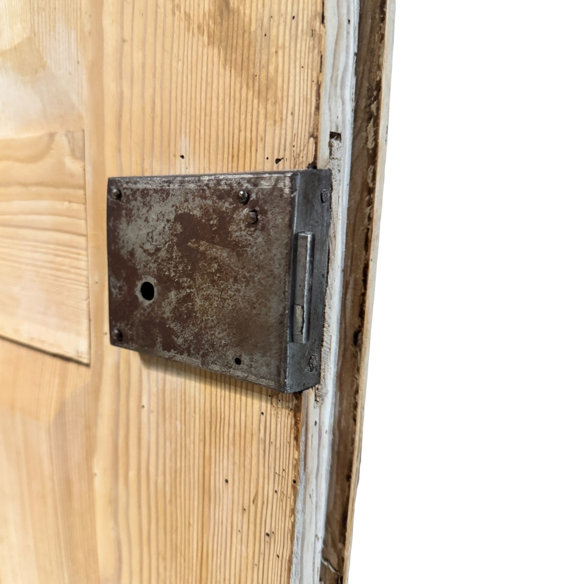 Close-up of old surface-mounted iron lock fitted to the inside of an antique Victorian pine wardrobe door