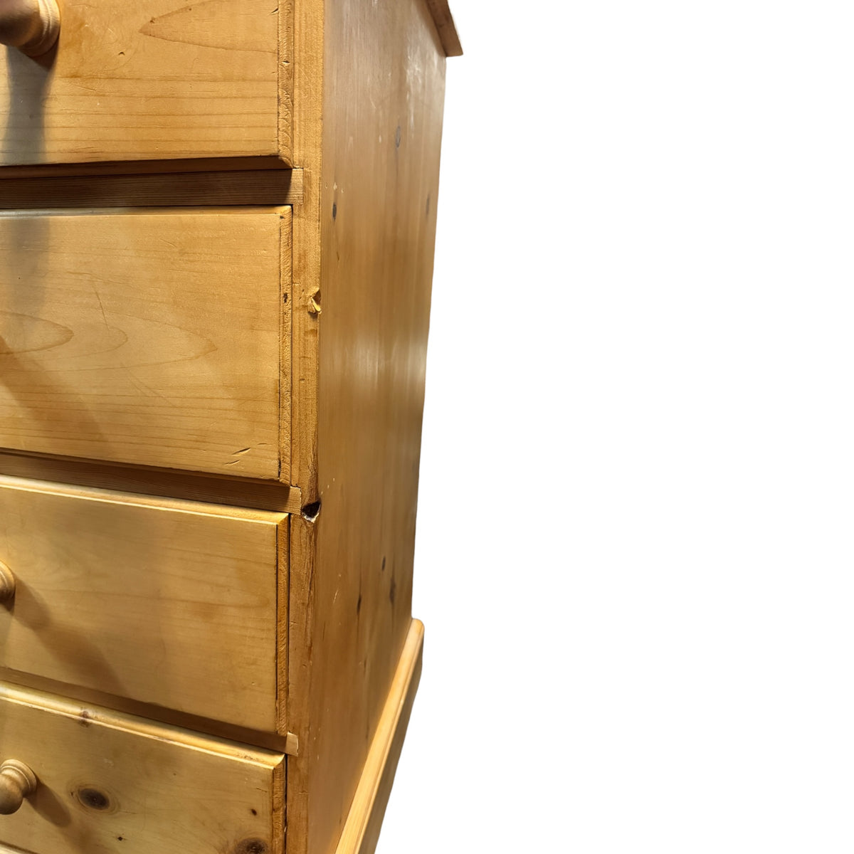 Close-up of the drawer edges and carcass on a vintage pine chest of drawers showing age-related wear and construction details.