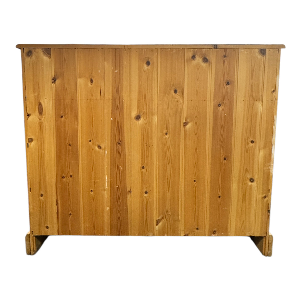 Rear view of a vintage pine chest of drawers showing the vertical boarded pine back and solid timber construction.