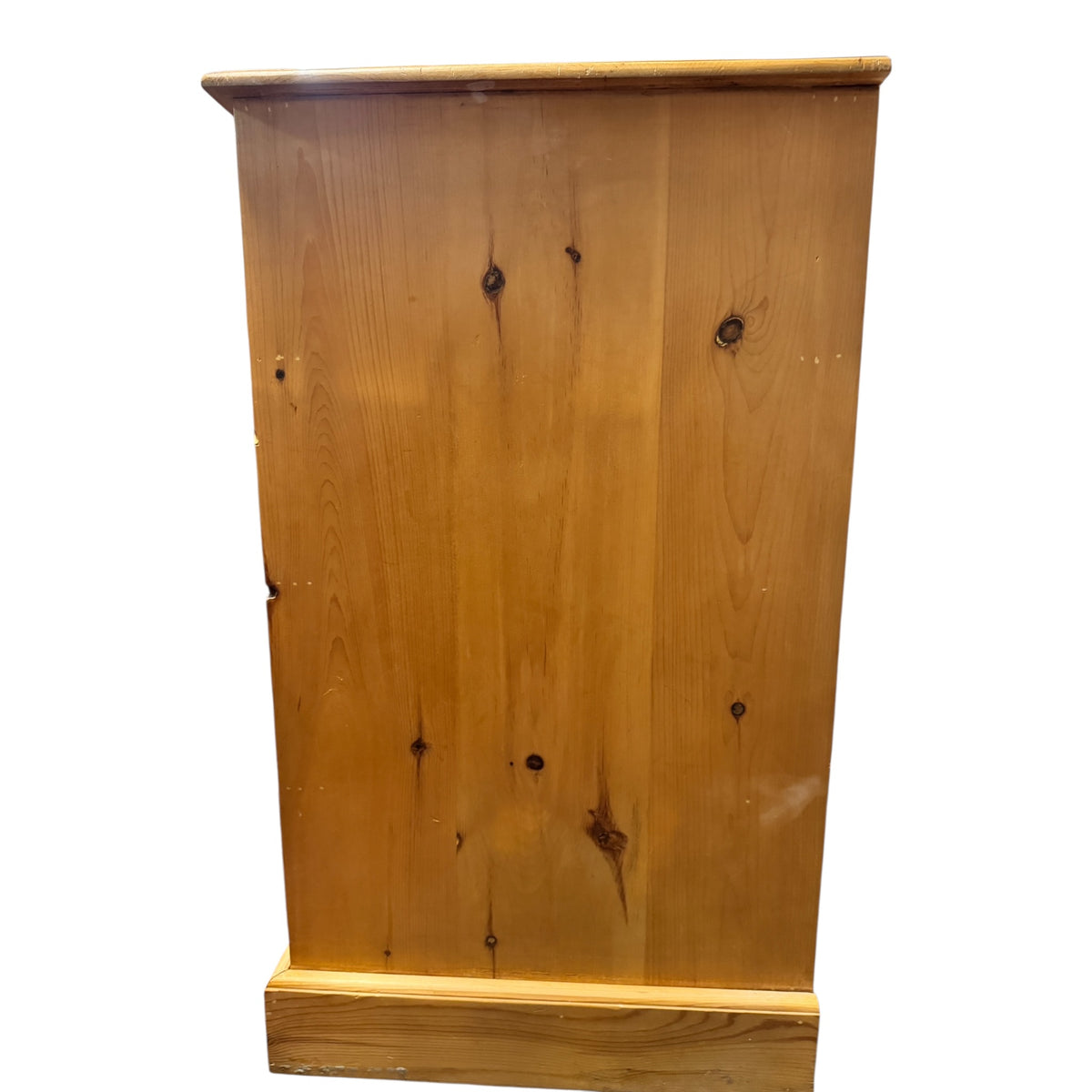 Detailed side view of a vintage pine chest of drawers showing the wide pine boards, knots and mellow aged finish.