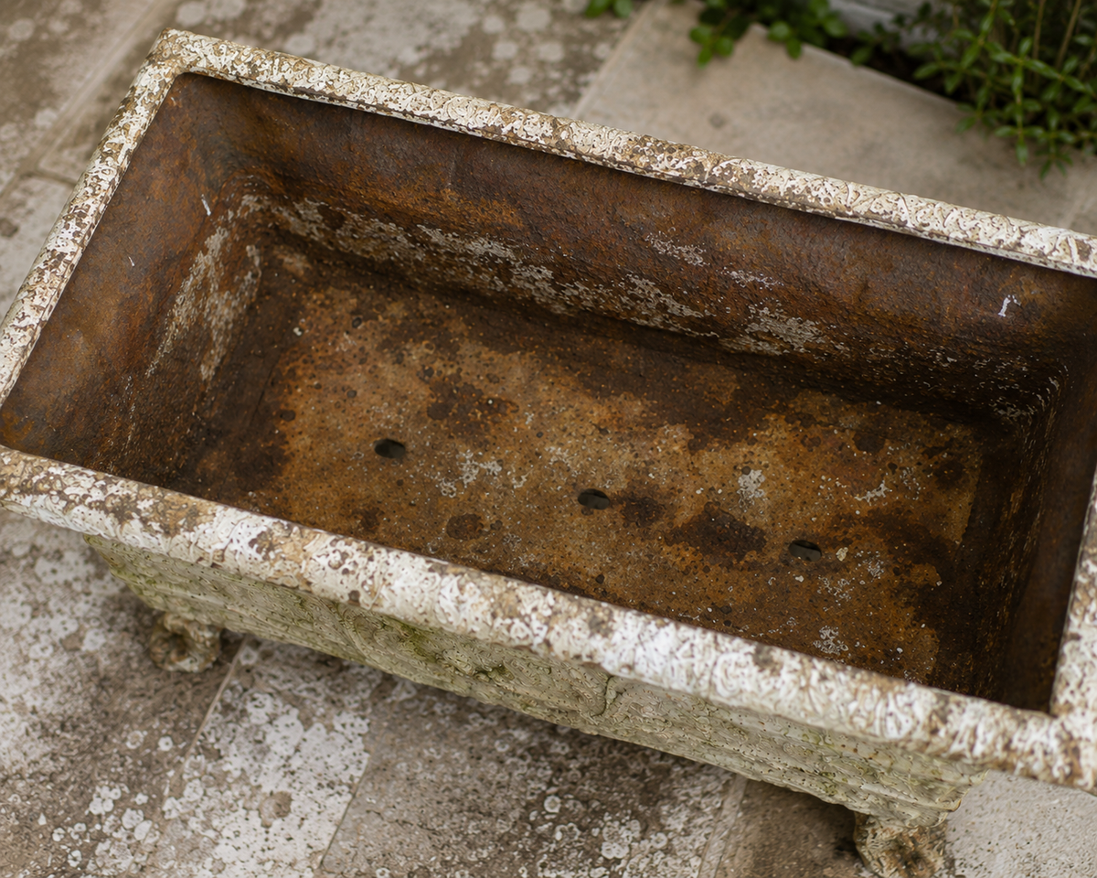 Top view inside antique cast iron garden planter showing aged and oxidised interior